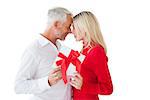 Smiling couple passing a wrapped gift on white background