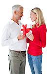 Smiling couple embracing and holding gift on white background