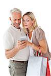 Happy couple holding shopping bags and smartphone on white background