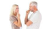 Couple staying silent with fingers on lips on white background