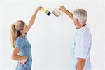 Happy couple painting wall with paintbrushes on white background