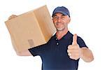 Happy delivery man holding cardboard box showing thumbs up on white background