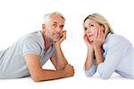 Thoughtful couple lying and looking up on white background