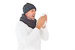 Sick man in winter fashion sneezing on white background