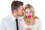 Handsome man kissing girlfriend on cheek holding a rose on white background