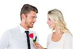 Handsome man smiling at girlfriend holding a rose on white background