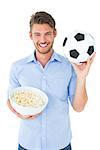 Handsome young man holding ball and popcorn on white background