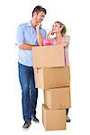 Attractive young couple leaning on boxes with piggy bank on white background