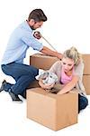 Young couple packing moving boxes on white background