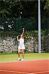 Pretty tennis player serving the ball on a sunny day