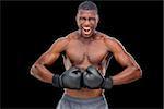 Portrait of a shirtless muscular boxer flexing muscles over black background