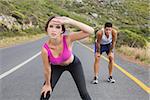 Fit young couple running on the open road together