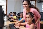 Cute pupils in computer class with teacher at the elementary school