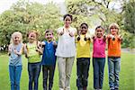 Pretty teacher standing with pupils outside at the elementary school