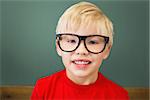 Cute pupil smiling at camera in classroom at the elementary school