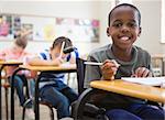 Disabled pupil smiling at camera in classroom at the elementary school