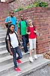 Cute pupils smiling on the stairs outside at the elementary school