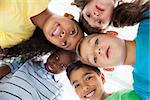 Cute schoolchildren smiling at camera from above on white background