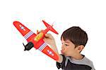 Happy little boy playing with toy airplane on white background
