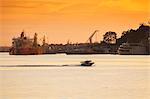 South America, Brazil, Amazon, Amazonas, Manaus, a speedboat passing in front of cargo ships at the industrial docks