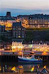 United Kingdom, England, North Yorkshire, Whitby. A view of the harbour at dusk.