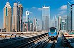 Metro train with city skyline in the background, Dubai, United Arab Emirates