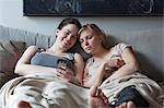 Two young woman reading text message