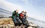 3 boys eating fruit at lake