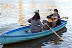 Man playing guitar in row boat