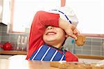 Young boy eating cookie in kitchen