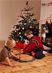 Two young boys playing with a train set