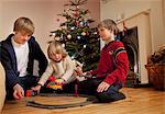 Three boys playing with a train set