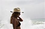 Girl with straw hat, water splashing behind her