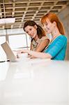 Businesswomen using laptop together