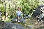 Boy sitting on rock