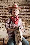 Young girl dressed as cowgirl with rocking horse