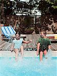 Boy and girl splashing in swimming pool