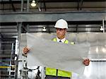 Mature man with blueprint in factory