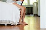 Legs of woman on bed with tissue box