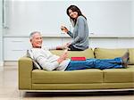 Mature couple sitting on sofa with wine