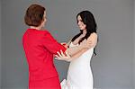 Daughter trying on wedding dress, embracing mother