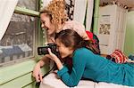 Teenage girls looking through window taking photograph