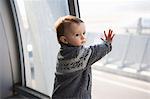 Boy touching airport window