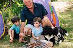 Grandfather and grandsons having barbecue