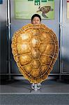 Boy standing behind loggerhead sea turtle shell