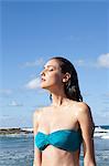 Woman on beach with eyes closed