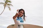 Young woman holding surfboard, portrait