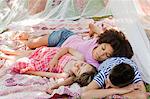 Three friends sleeping in summer netting tent