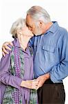 Senior couple kissing against white background