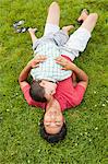 Father lying on grass with son